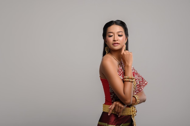 Photo gratuite belle femme thaïlandaise vêtue d'une robe thaïlandaise et regardant sur le côté