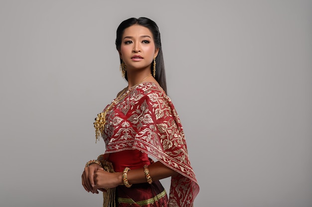 Belle femme thaïlandaise vêtue d'une robe thaïlandaise et regardant en haut