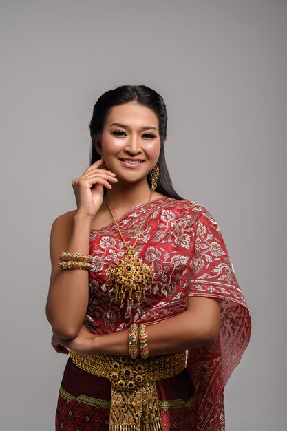 Belle femme thaïlandaise vêtue d'une robe thaïlandaise et d'un sourire heureux.