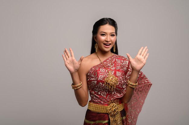 Belle femme thaïlandaise vêtue d'une robe thaïlandaise et d'un sourire heureux.