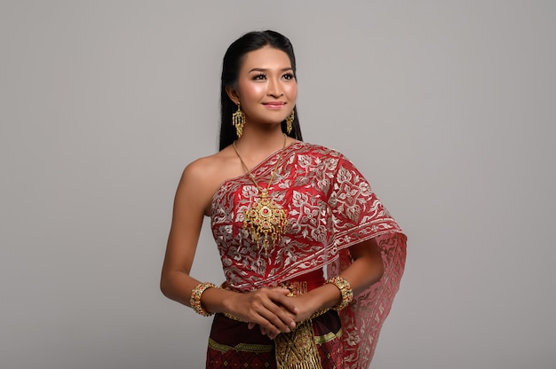 Belle femme thaïlandaise vêtue d'une robe thaïlandaise et d'un sourire heureux.