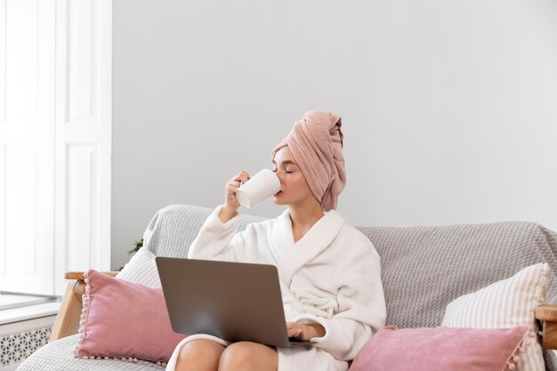 Belle femme travaillant après avoir pris un bain