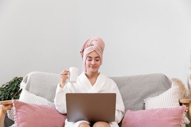 Belle femme travaillant après avoir pris un bain