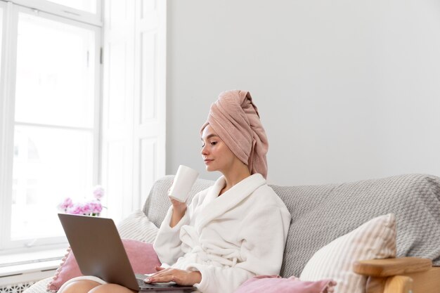 Belle femme travaillant après avoir pris un bain