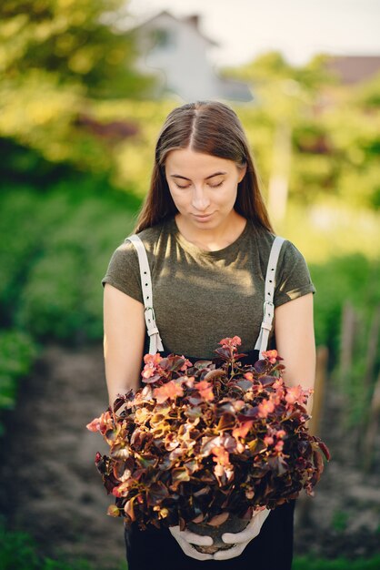 Belle femme travaille dans un jardin près de la maison