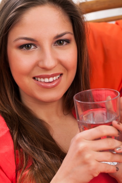 Belle femme avec un verre à la maison