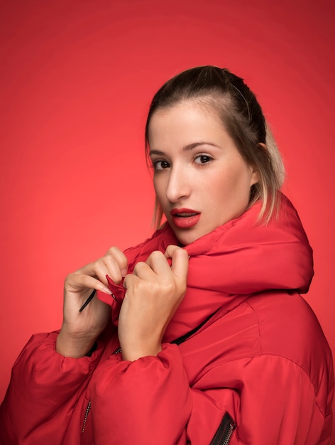 Belle femme en veste rouge pose