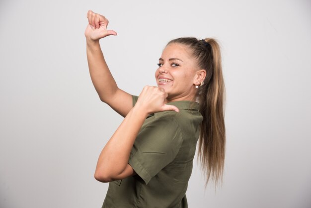 Belle femme en veste verte appelant quelqu'un.