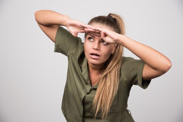 Belle femme en veste verte essayant de voir.