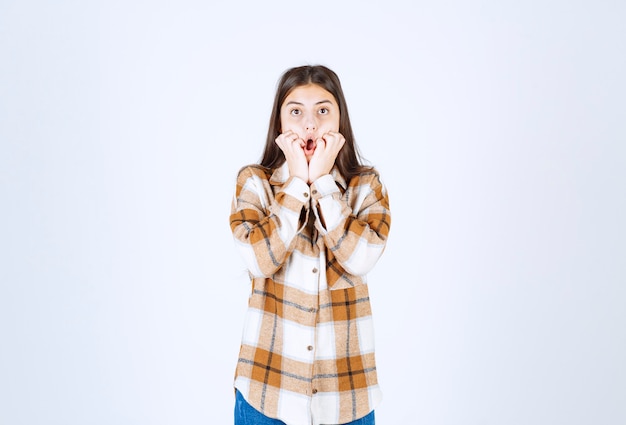 Belle Femme En Vêtements Décontractés Tenant Sa Tête Sur Un Mur Blanc.