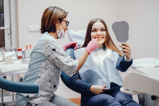 Belle fille assise dans le bureau du dentiste