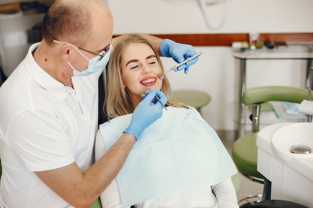 Belle fille assise dans le bureau du dentiste