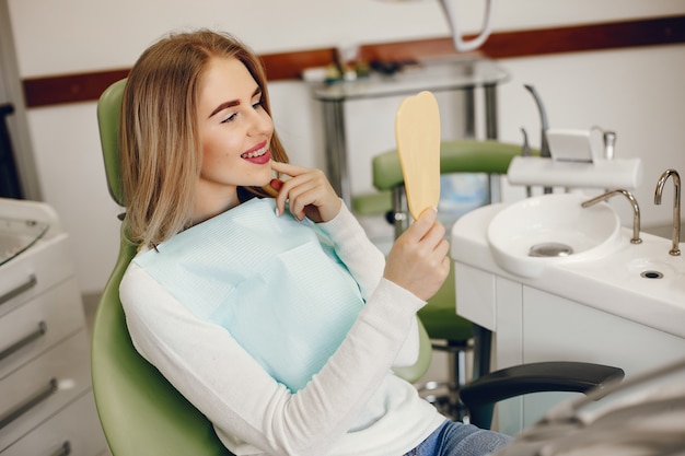 Belle fille assise dans le bureau du dentiste