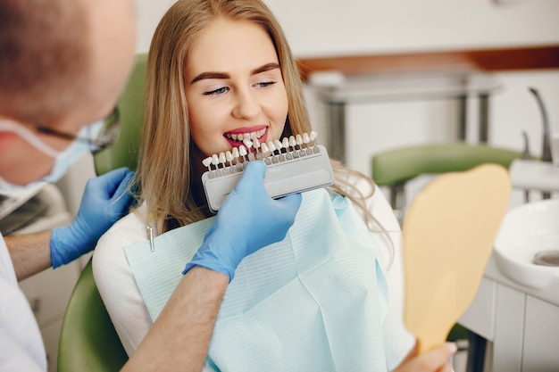 Belle fille assise dans le bureau du dentiste