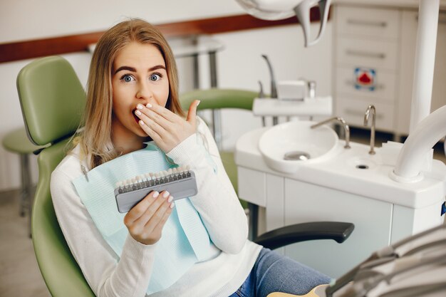 Belle fille assise dans le bureau du dentiste