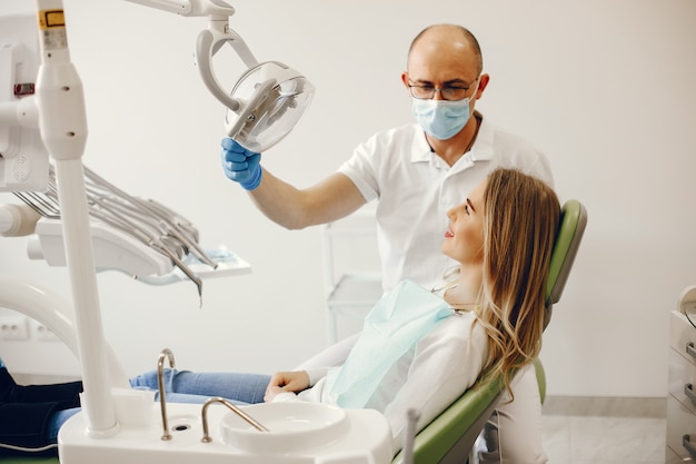 Belle fille assise dans le bureau du dentiste