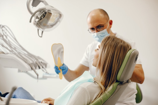 Belle fille assise dans le bureau du dentiste