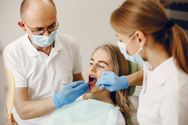 Belle fille assise dans le bureau du dentiste