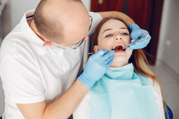 Belle fille assise dans le bureau du dentiste