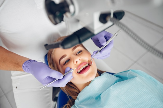 Belle fille assise dans le bureau du dentiste