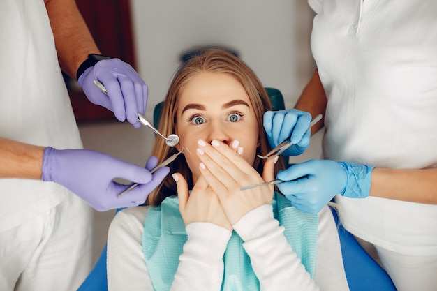 Belle fille assise dans le bureau du dentiste