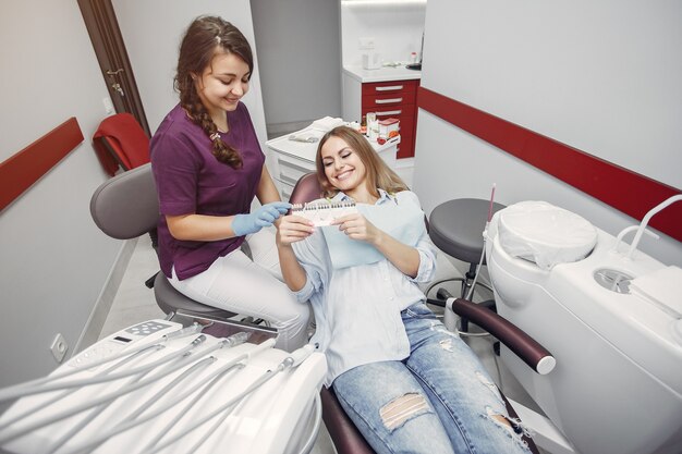 Belle fille assise dans le bureau du dentiste