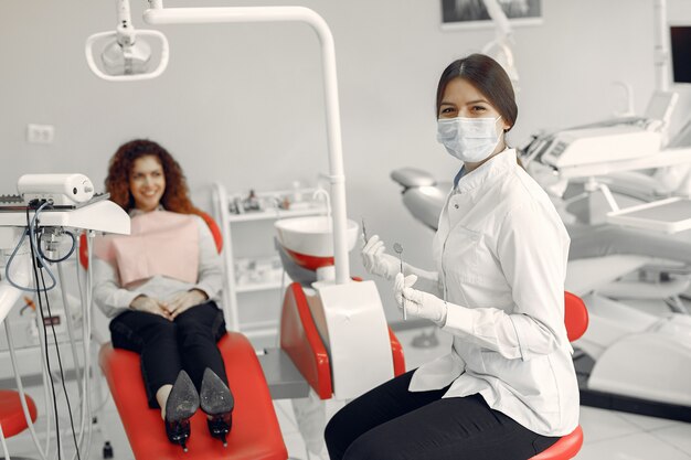 Belle fille assise dans le bureau du dentiste