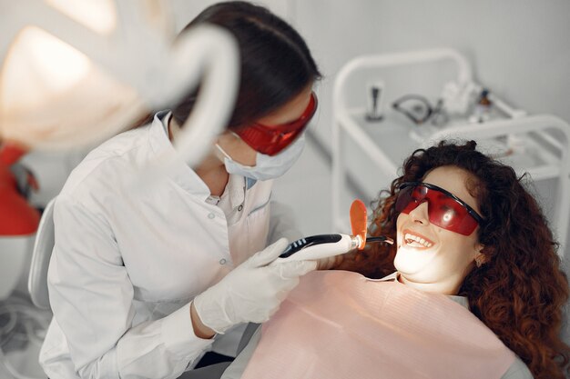 Belle fille assise dans le bureau du dentiste