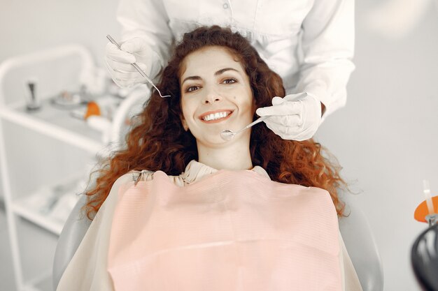 Belle fille assise dans le bureau du dentiste