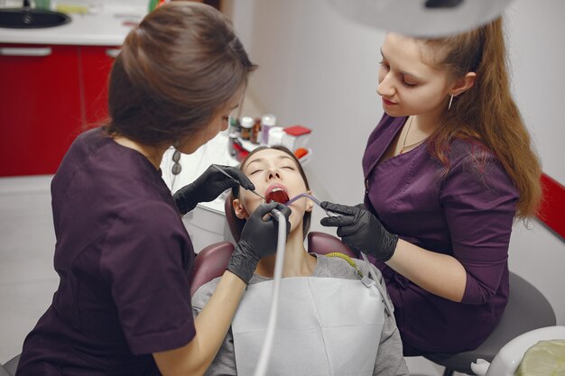 Belle fille assise dans le bureau du dentiste