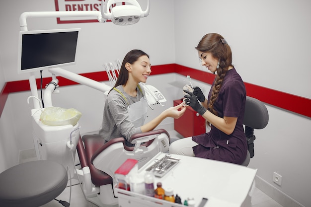 Belle fille assise dans le bureau du dentiste