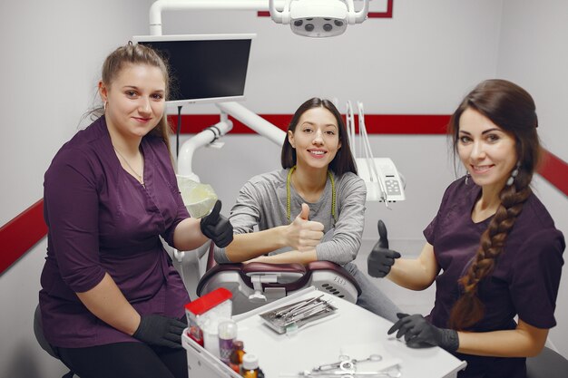 Belle fille assise dans le bureau du dentiste