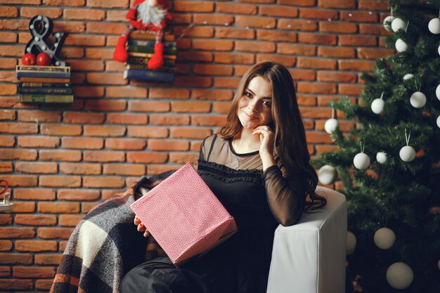 Belle fille assise dans une chambre de noël