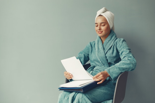 Belle fille assise dans un peignoir bleu