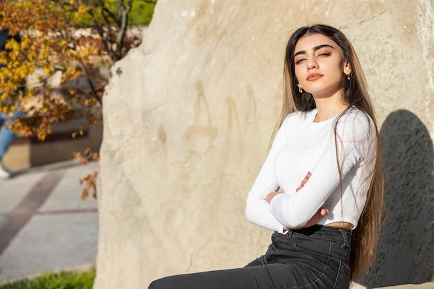 Belle fille assise dans la rue par une journée ensoleillée