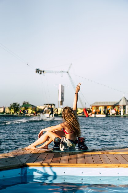 belle fille aux cheveux longs avec un wakeboard