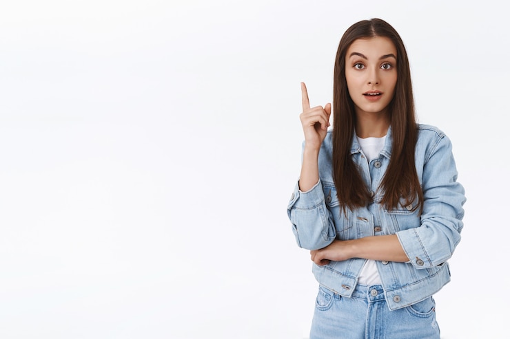 Photo gratuit une belle fille créative et intelligente a une excellente idée, s'illumine avec un plan génial, lève un doigt dans le geste eureka, suggère une solution, dit ses pensées à voix haute, fond blanc