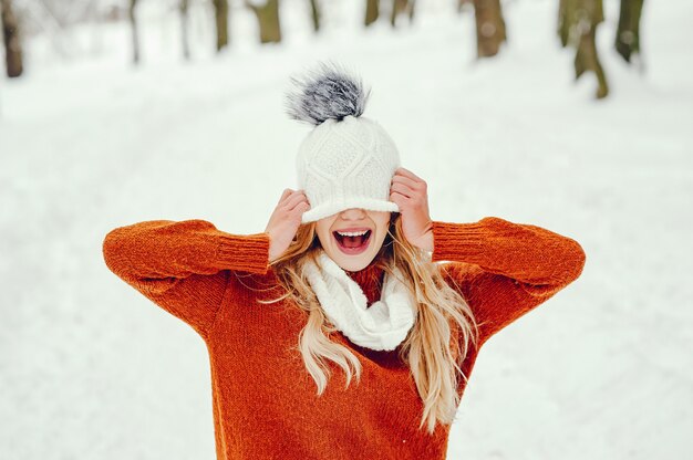 Belle fille dans un joli pull orange