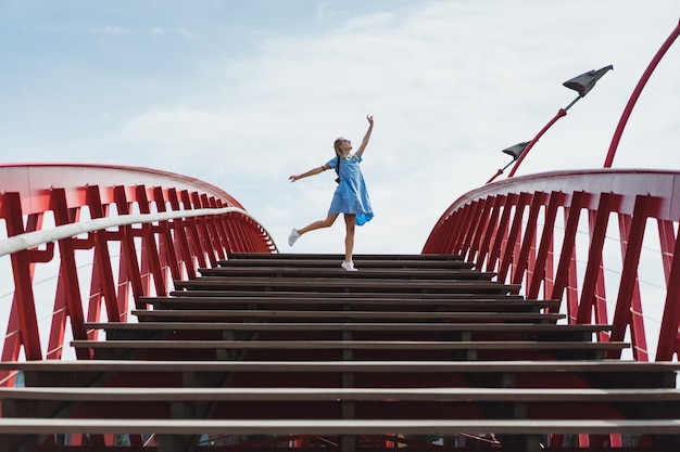 belle fille dans une robe bleue posant sur le pont