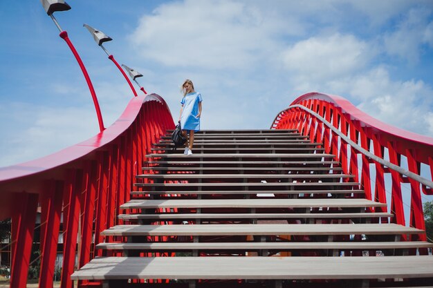 belle fille dans une robe bleue posant sur le pont