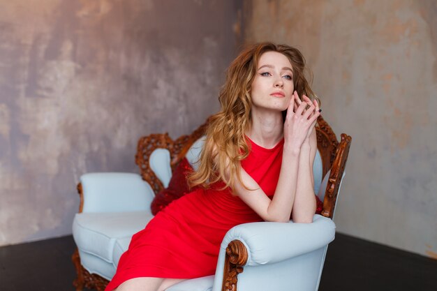 Belle fille dans une robe rouge incroyable sur un fond de loft rustique minimal