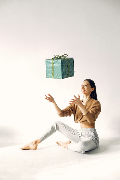 Belle fille debout dans un studio avec des cadeaux