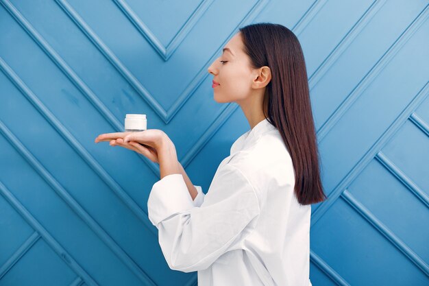 Belle fille debout dans un studio avec de la crème