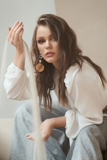 Belle fille avec du sable tombant entre les mains en studio