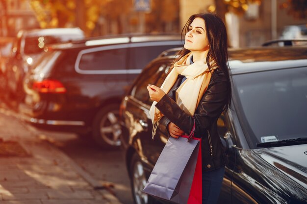 belle fille élégante se promener dans la ville avec des sacs à provisions