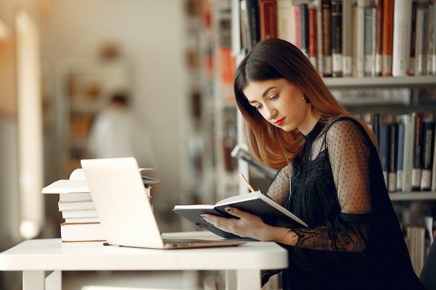 Belle fille étudie à la bibliothèque