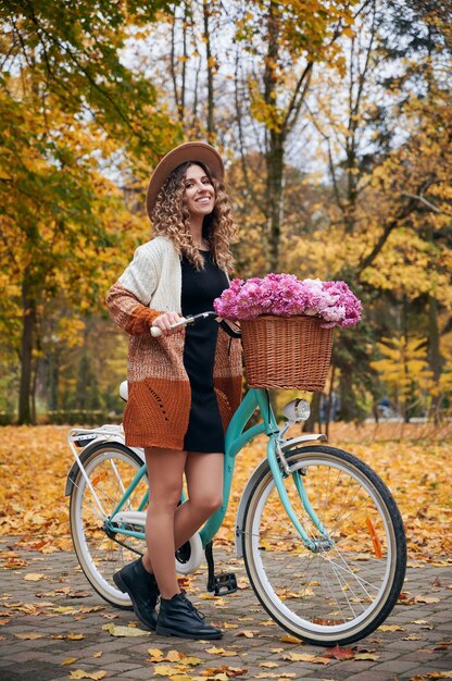 Belle fille à l'extérieur avec le vélo rétro de la femme