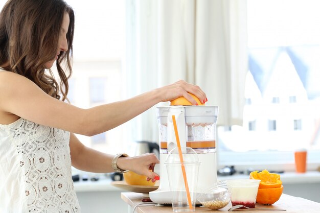 Belle fille faisant du jus d'orange