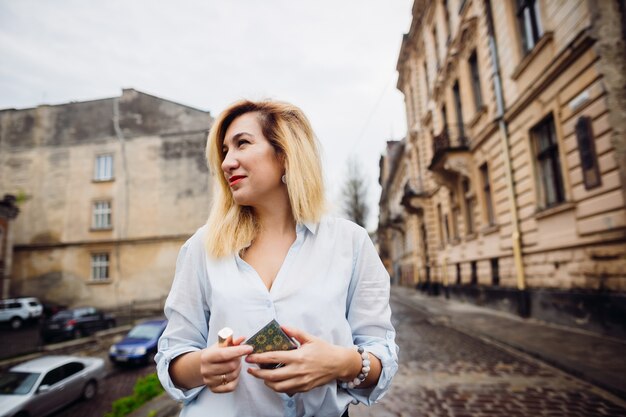 La belle fille garde le miroir et le rouge à lèvres