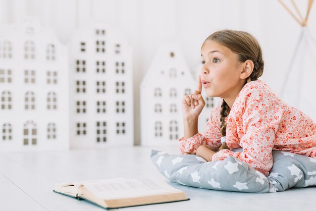 Belle fille heureuse posant avec un livre